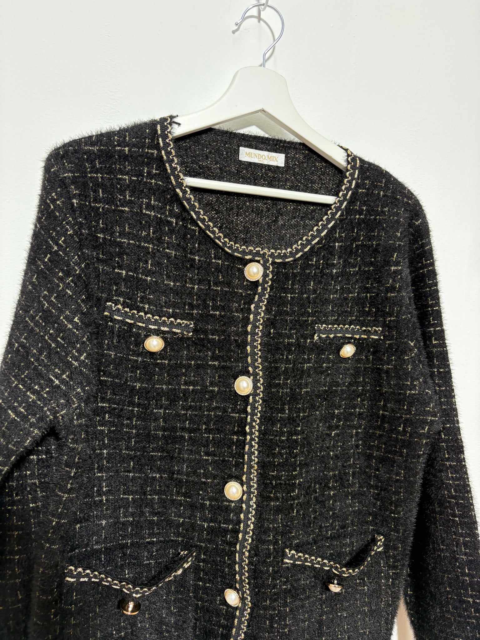 Chaqueta corte  mujer “Sierra Negra” en tono oscuro con botones de perla, ribete dorado y dibujo de cuadros – Trapío